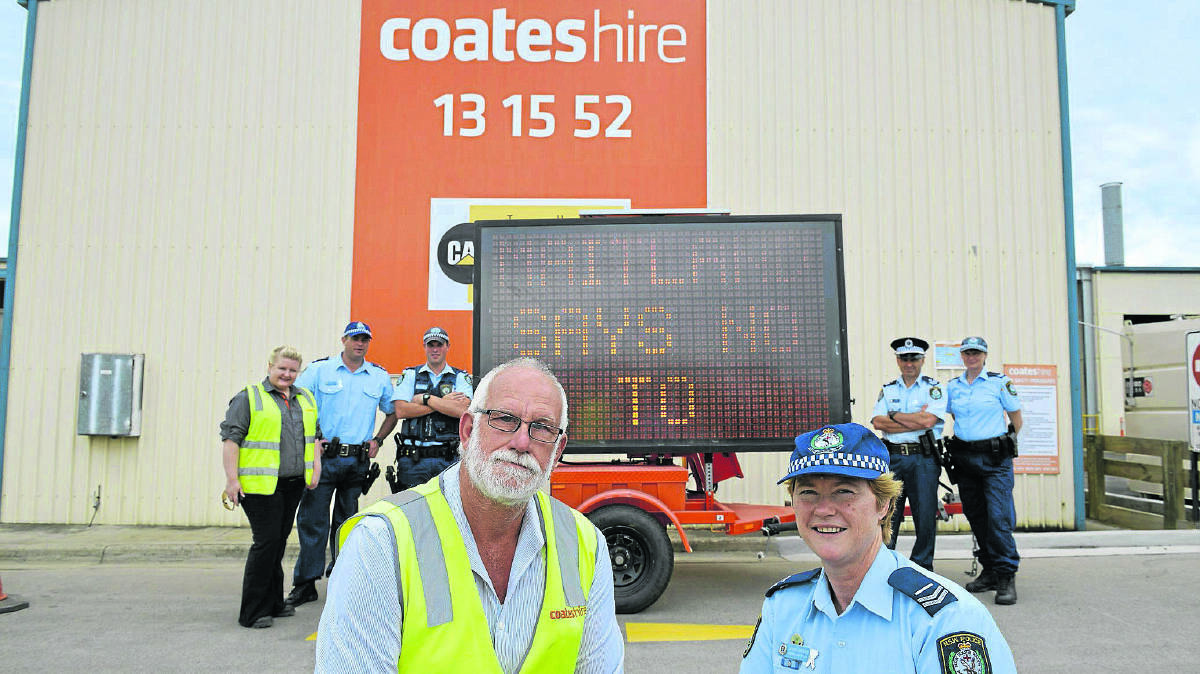 SIGN OF TIMES:  Coates Hire branch manager Iva Wills and Senior Constable Jenny Brown with one of the anti-domestic violence signs.	Picture by STUART SCOTT