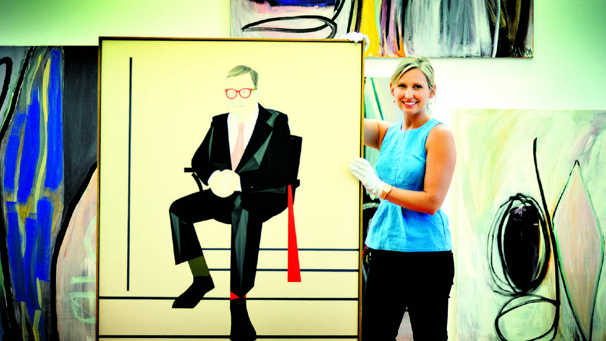 RARE OPPORTUNITY: Maitland Regional Art Gallery arts administrator Kate Bugeja hangs the Archibald entries.  	Picture by CATH BOWEN 