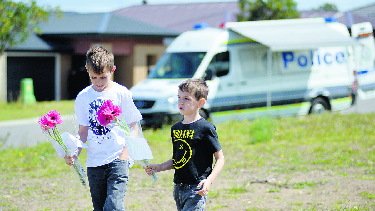 CHILDREN’S TRIBUTE:  Brayden, 8, and Jiah Whybrow, 6, take flowers to the murder scene.  	Pictures by CATH BOWEN