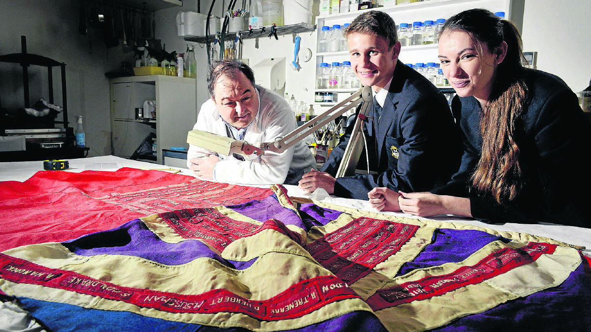 WORK AT HAND:  Flag conservator Duncan Harty with Maitland High School captains Mark Winter and Daynah Elford.    	Picture by STUART SCOTT 