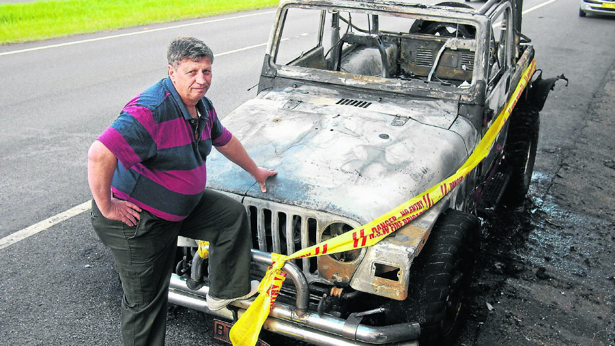 UNSCATHED: Brian Thurling with the burnt-out wreck that was once his beloved Jeep Wrangler.