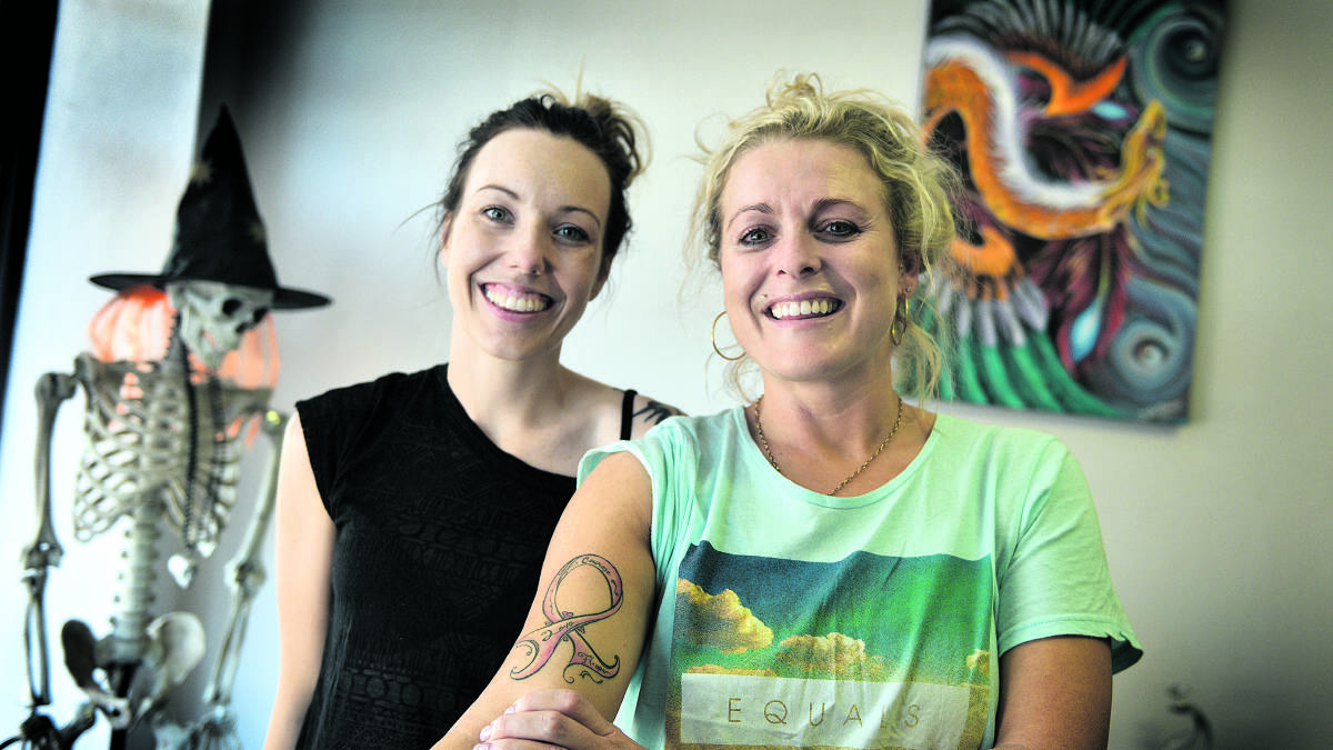 HEARTFELT:  Tattooist Ash Tasker with Anne Stewart showing her pink ribbon tattoo.  
   	Picture by CATH BOWEN 