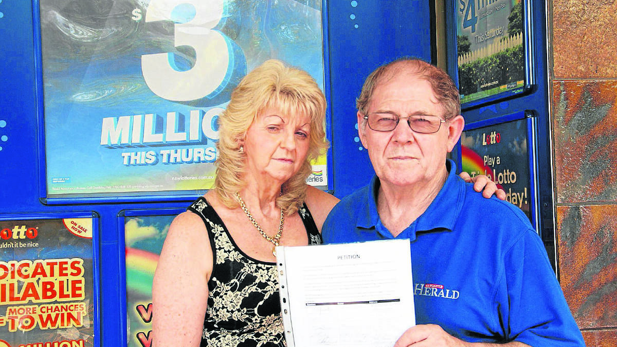 PETITION:  West End Newsagency owners Lyn and Lindsay Patfield with the petition to stop supermarket giant Woolworths selling lottery tickets.  	Picture by ALAN HARDIE 