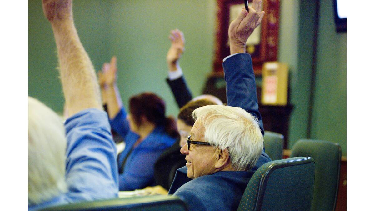 THE VOTE: Cr Brian Burke raises his hand along with most other Maitland councillors to accept a merger with Dungog Shire Council.