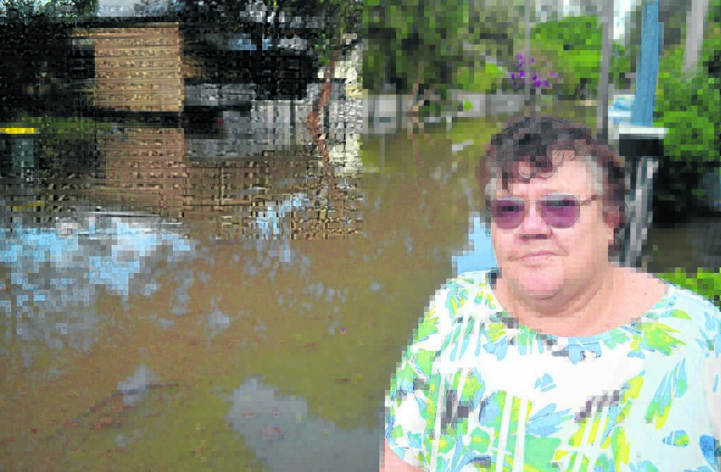 FLOODED: Dorothy Morrison inspects the flood damage in Bourke Street, Maitland.