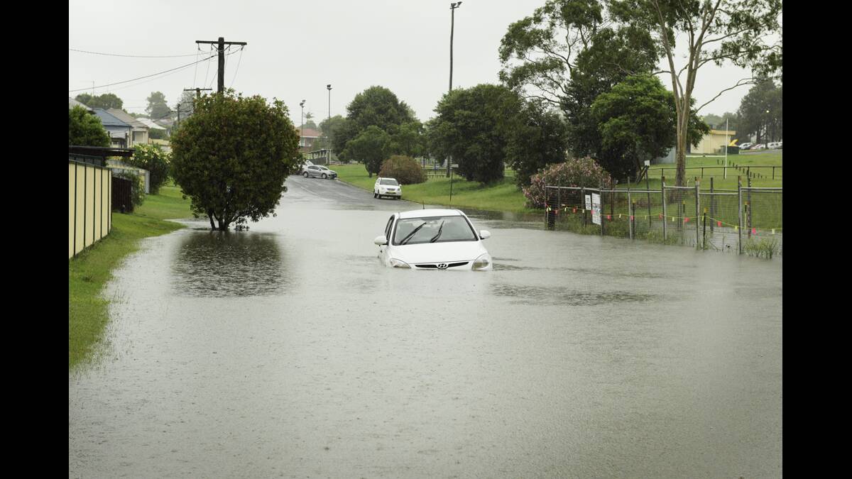 A car trapped by flood water in Bligh Street, Telarah.