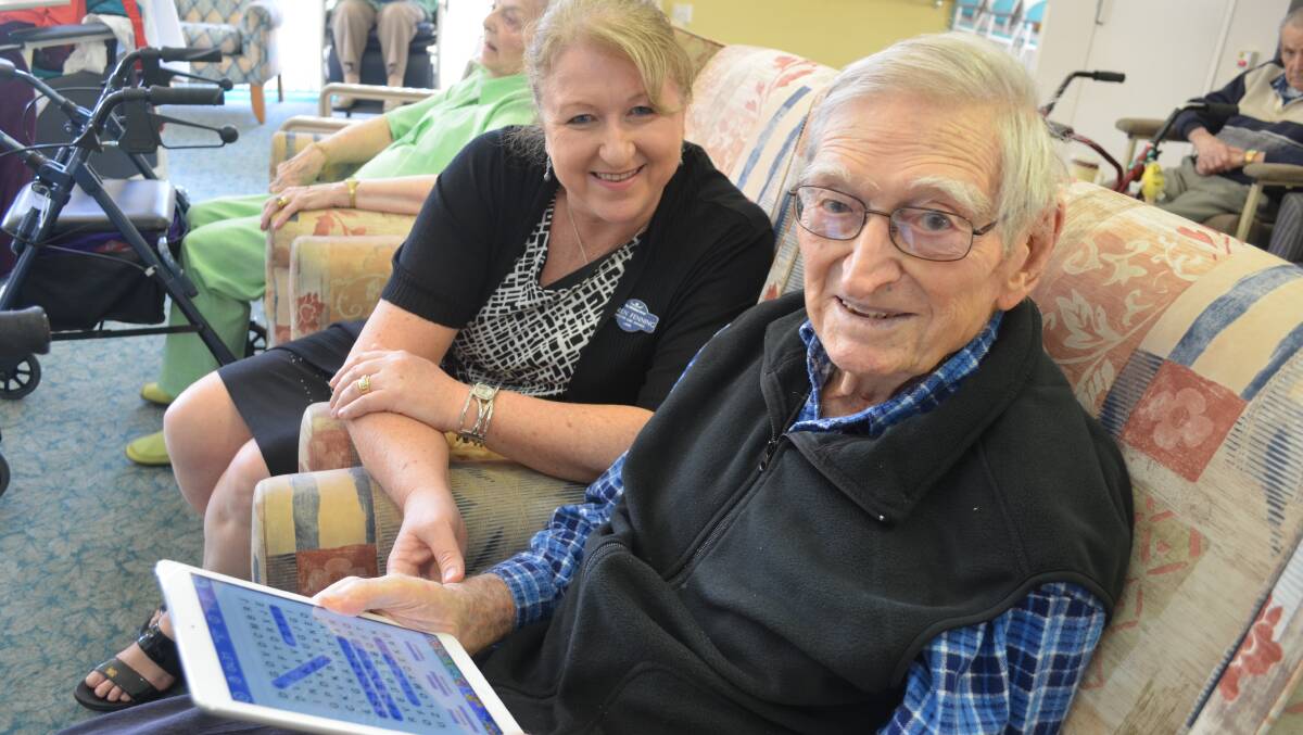 IPAD DONATION: Cecil Saxby has embraced the digital version of his favourite old pastime, find-a-word, with some help from Whiddon Group care services director Karen Fenning.  Picture by SAM NORRIS