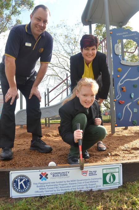 Kiwanis president Steve Mulquiney and Maitland MP Robyn Parker open a new playground with Year 5 student Phoebe Humphreys.