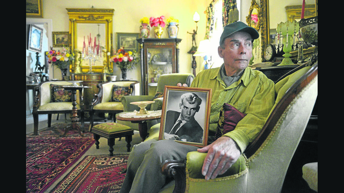 WHAT NO CHILD SHOULD HAVE TO ENDURE: Bruce Tindale, pictured with a photo of himself as a young man,  never married or had children as he did not want to inflict on them the pain he experienced as a child.  