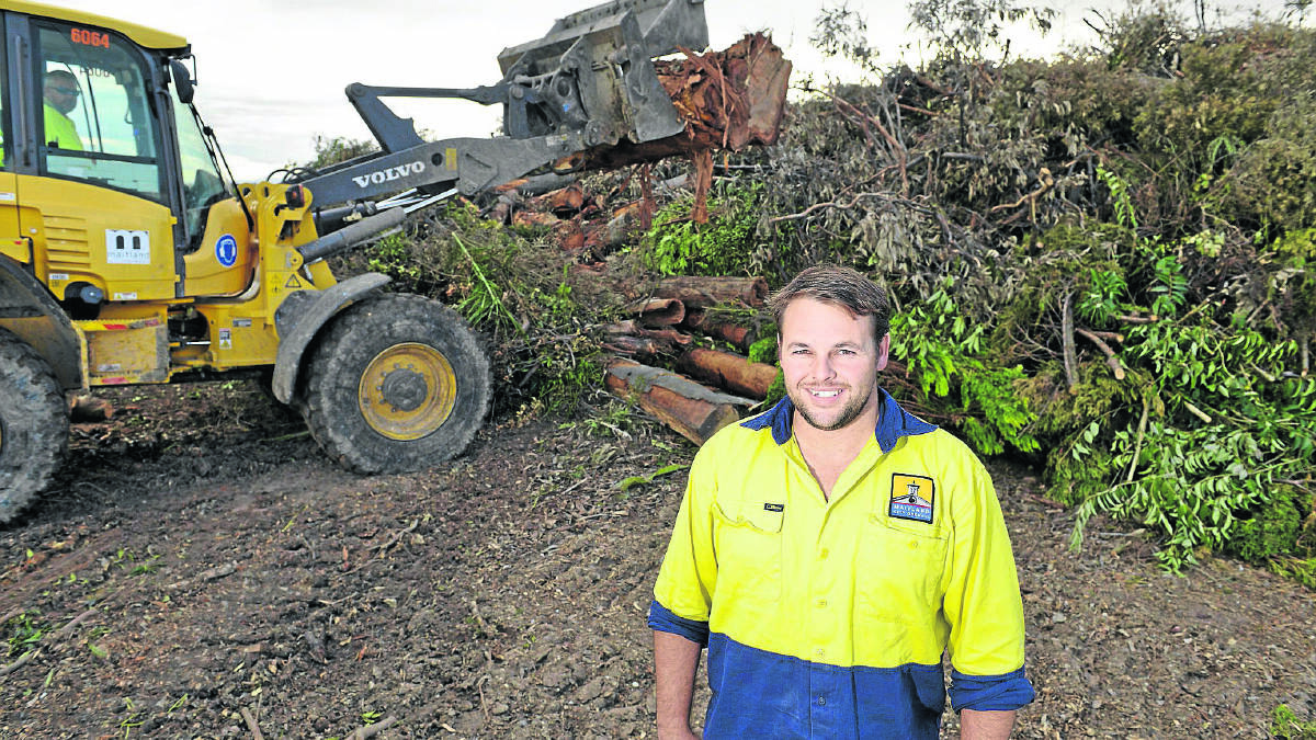 Acting waste services supervisor Brian Hampton beside some of the green waste from the superstorm.