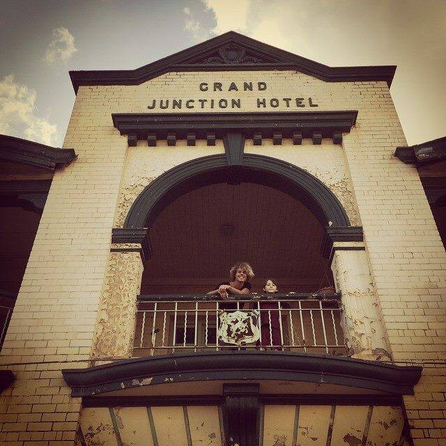 Kim Churchill and Darcy Quinn smile from the upstairs balcony of Maitland's Grand Junction Hotel yesterday, ahead of the first of Churchill's two performances at the pub this week. Picture: Facebook