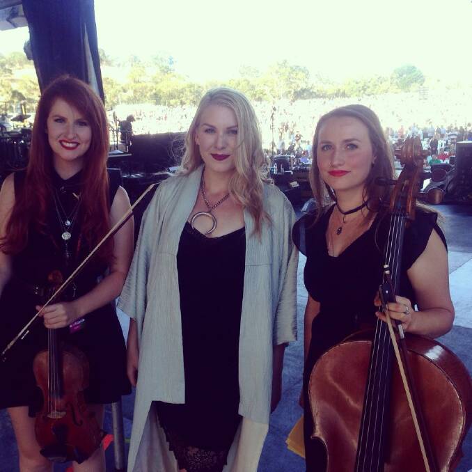 BIG CROWD:  Melody Pool (centre) poses with her glamorous string ­section on stage at her Hanging Rock performance.	Facebook