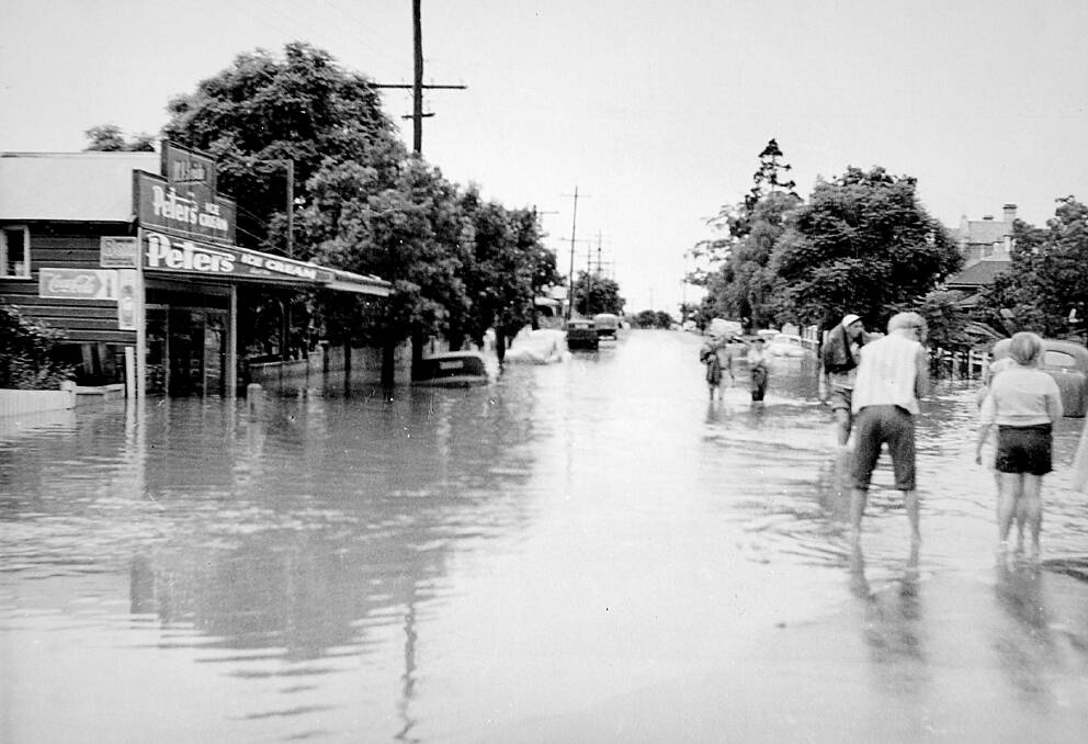 UNDER WATER: Regent Street in the great flood of 1955, with children playing in the street, and people ­wading through knee-deep water.  Below: how it looks from that same spot today. 