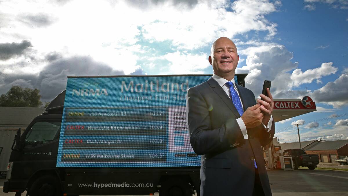 WIN FOR MOTORISTS: NRMA president Kyle Loades uses the new petrol price app at East Maitland. Picture: Marina Neil