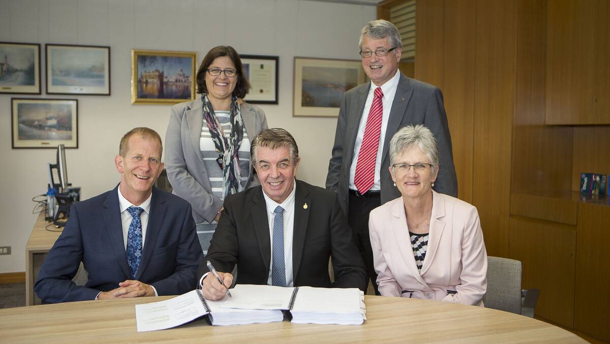 Opportunity: Disability Services Minister Ray Williams signs the contract with Heather Scheibenstock (Ability Options Board Member), Dudley Johnson (AO Business Development Manager and HVDS Director), David Carey (CEO ConnectAbility Australia and HVDS Director) and Patricia Biszewski (Ability Options Board Member). Picture: Supplied