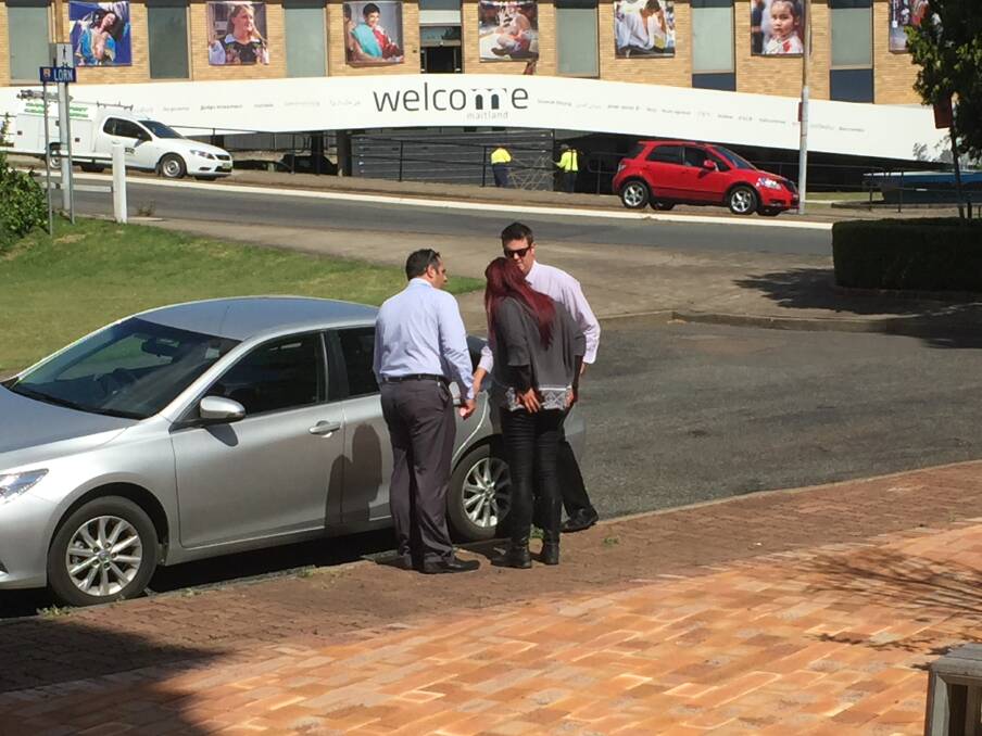 INVESTIGATION: Detectives arrest a woman outside Maitland courthouse on Monday. 