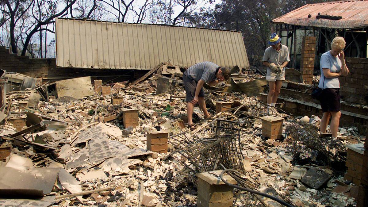 Owners of a house destroyed by a bushfire in 2001 sift through the rubble for valuables in the township of Warrimoo, located in the Blue Mountains. Photo: REUTERS