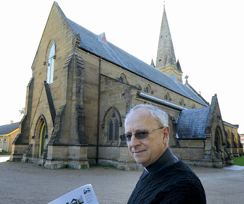 SHORTFALL:  Father Chris Butterworth with plans for the 4000-niche columbarium at St Mary’s Anglican Church.  