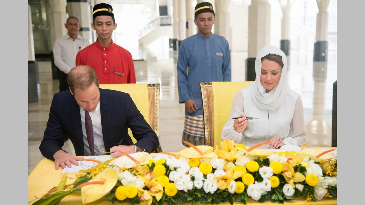 Catherine, Duchess of Cambridge and Prince William, Duke of Cambridge sign a visitors book during a visit to Assyakirin Mosque in September. Picture: Getty Images