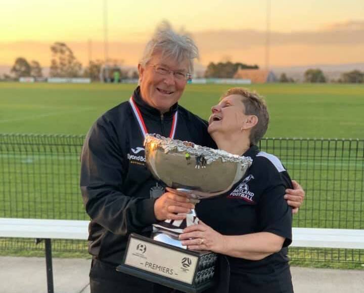 HAPPINESS: Paul and Margaret Osland with the Premier's Trophy in 2019 after Maitland Football Club won it for the first time in the club's 58 years of existence. Picture: Supplied.