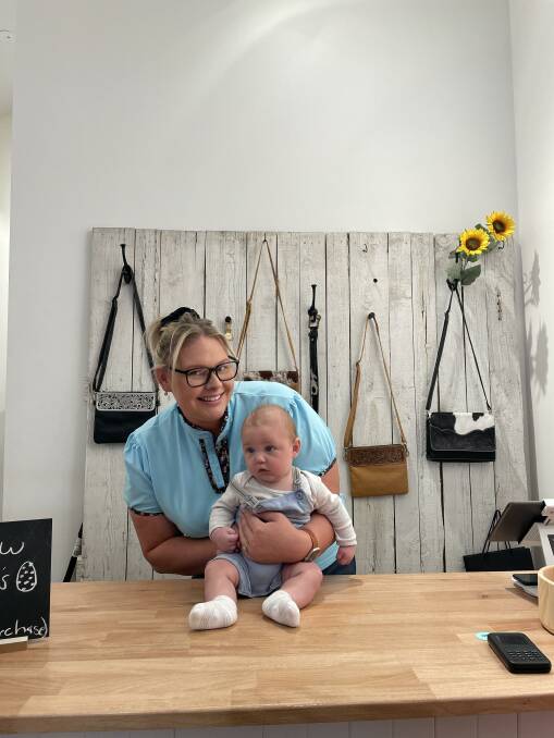Abby Wilson and four-month-old Parker behind the counter at Dust and Bullets Western in Green Hills. Picture by Chloe Coleman
