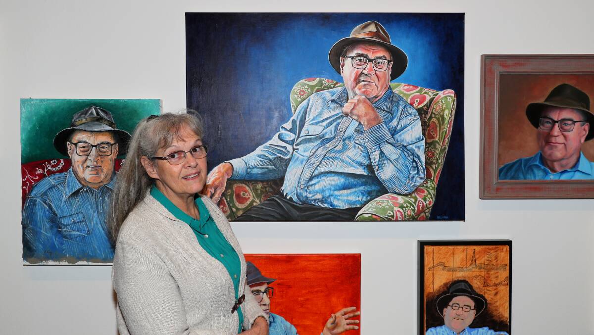 Maitland Region Society of Artists treasurer Jenny Dimmock with some of this year's Maitland Portrait Prize artworks of Dr Cameron Archer. Picture by Peter Lorimer.