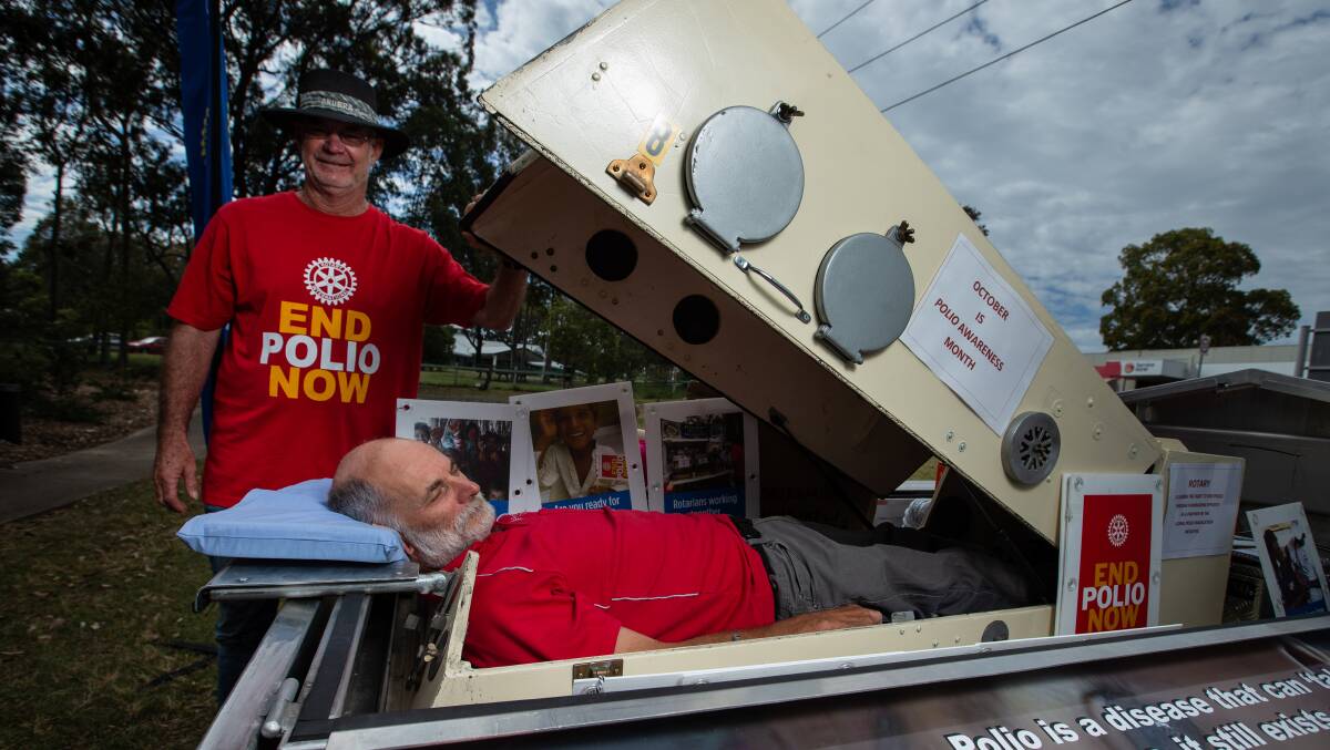 Rotary Club of East Maitland president Brian Morgan with member Michael Tams in an authentic iron lung, which will be on display at the walkathon. Picture by Marina Neil.