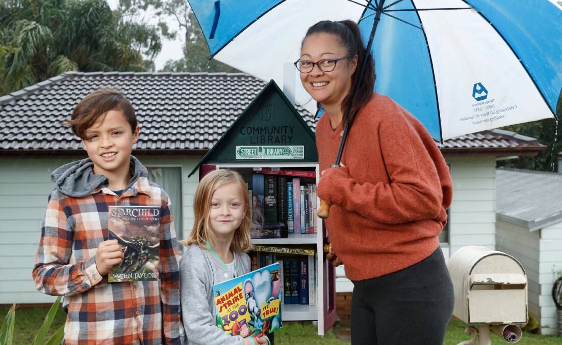 LIBRARIANS: Lauren Threadgate and her kids Billy (10) and Penny (seven) with the street library outside their home on Brigantine Street. Picture: Max Mason-Hubers.
