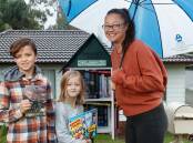 LIBRARIANS: Lauren Threadgate and her kids Billy (10) and Penny (seven) with the street library outside their home on Brigantine Street. Picture: Max Mason-Hubers.