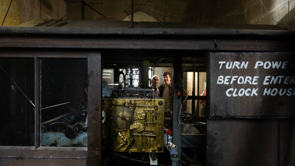 John Hamilton and Michael Thorne peek through the window of the St Mary's clock mechanism. Picture by Marina Neil