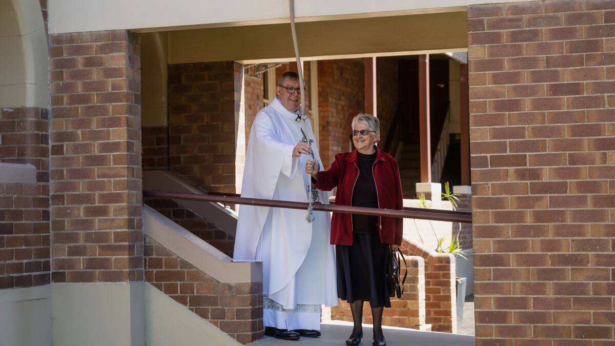 Bishop Brian Mascord and Sister Lauretta Baker ring the school bell. Picture by Marina Neil