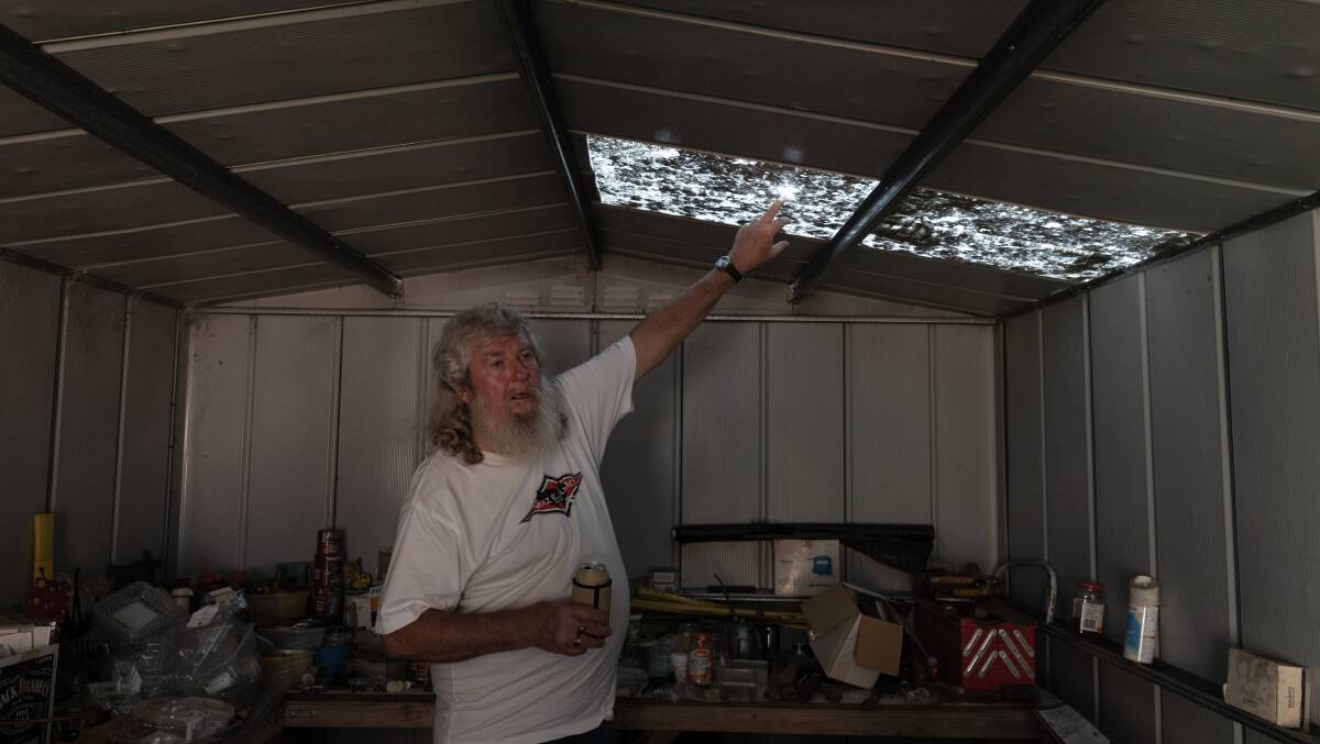 John Budynek inspects a damaged roof. Picture by Marina Neil 