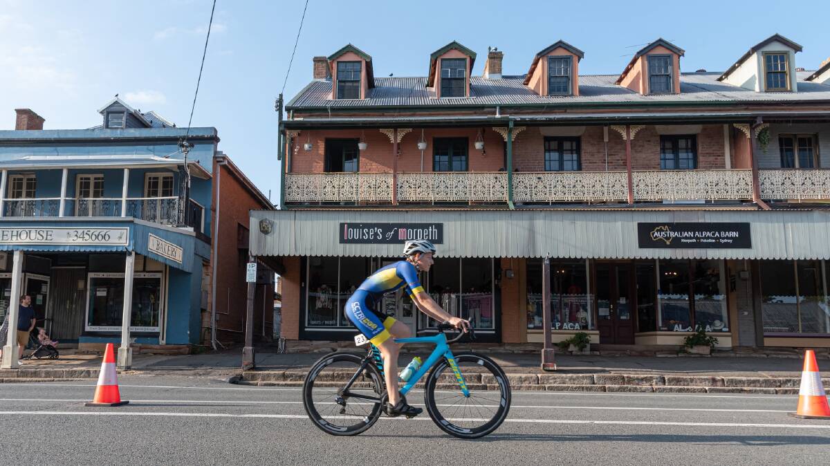A competitor rides down Swan street in Morpeth during the Maitland Triathlon held in March. Picture by Lee Piggott