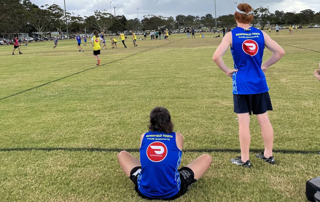 Two Beresfield touch football players watch a game from the sideline. Clubs and teams have until May 18 to apply for a grant to help with uniforms and equipment. Picture supplied