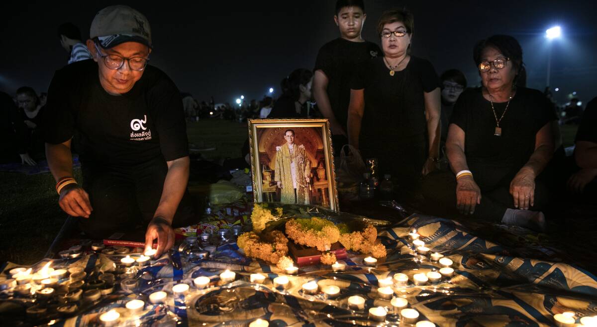 A ROYAL FAREWELL: Thais pray and light candles in memory of the late King of Thailand. Photo by Paula Bronstein/Getty Images