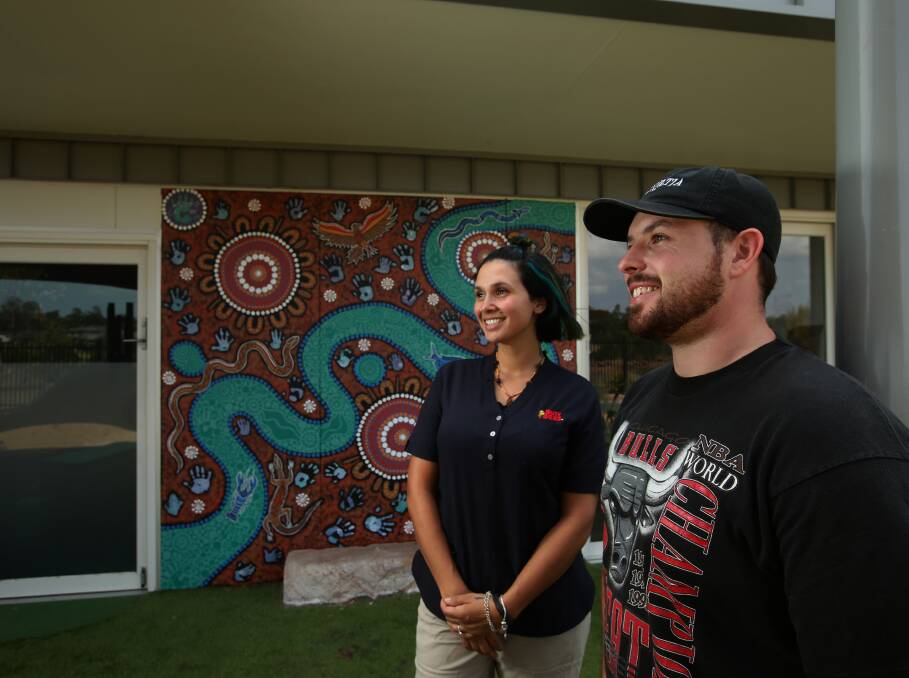ART: Busy Bees Heritage Parc education officer Kiara Eulo and artist Jakeob Watson with the Indigenous mural. Picture: Simone De Peak