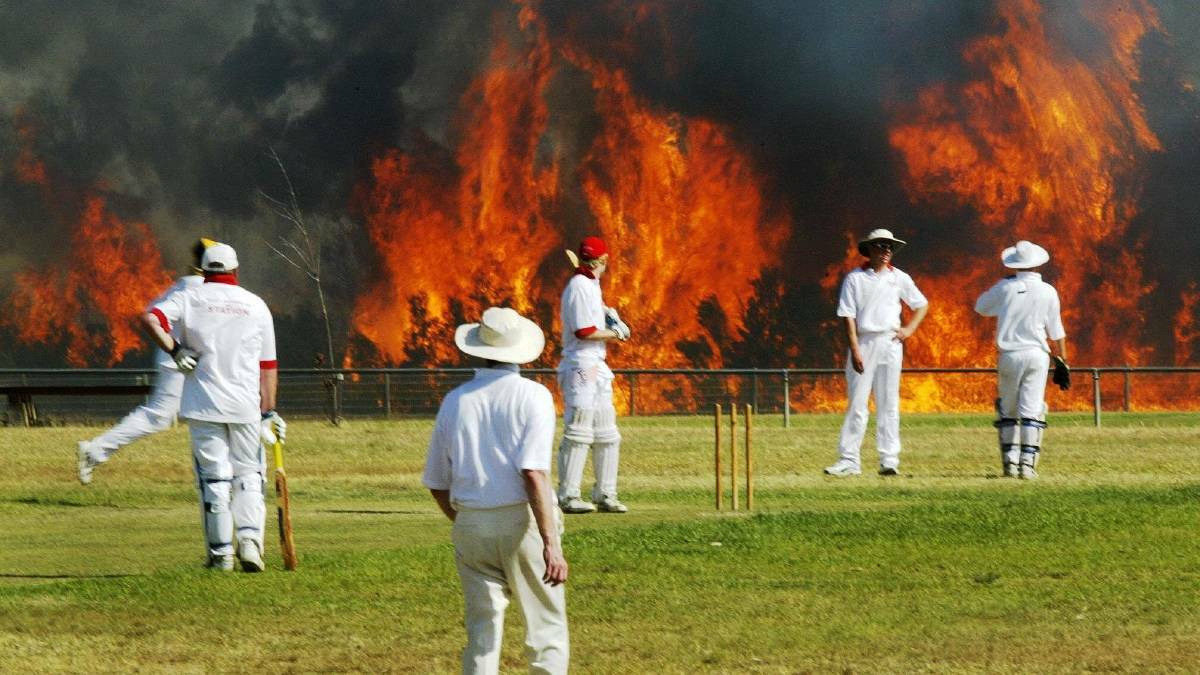 ICONIC IMAGE: There's something stoic cricketers that will see players stay on the field despite an approaching bushfire. Darren Pateman's Walkley-award winning photograph of the cricket match that took place at Cessnock as the bushfire approached in October 2002.