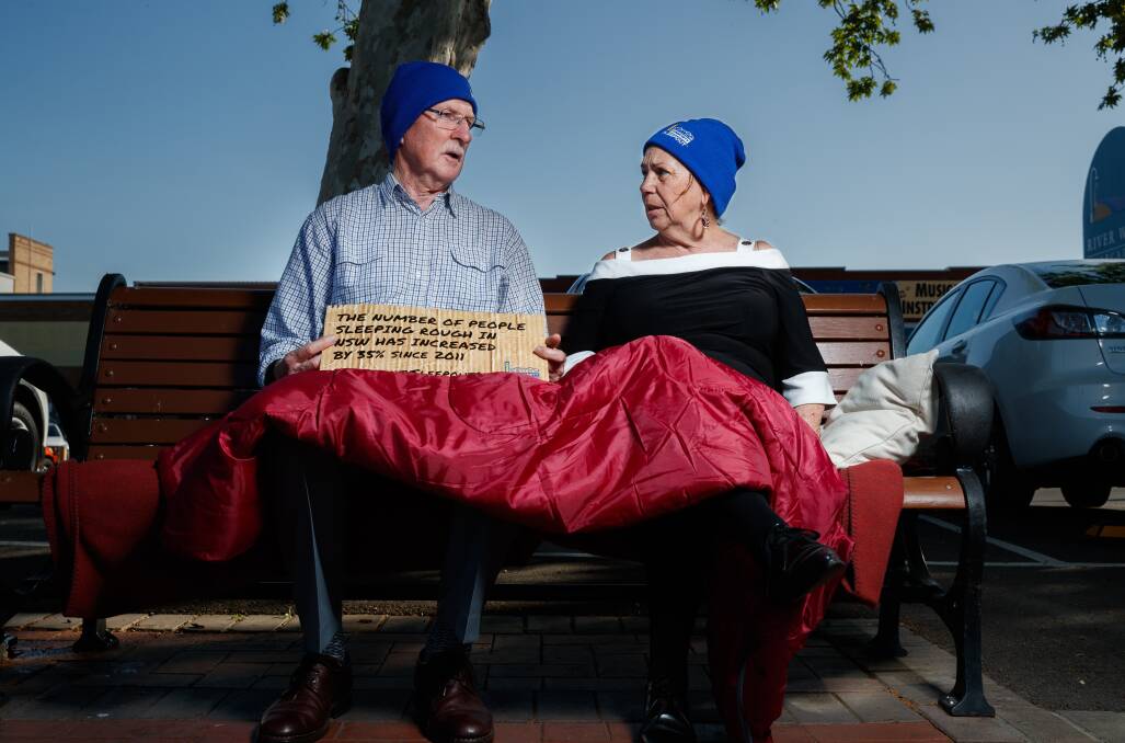 Michael Healy, regional president of St Vincent De Paul in the Lower Hunter and Maitland mayor Loretta Baker, laying in a mock bed on a park bench on the river walk. ahead of the sleepout. Picture: Max Mason-Hubers 