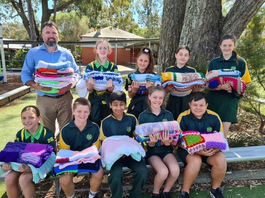 Year 6 students pictured with Thornton Public School Principal Stuart Wylie and the blankets.