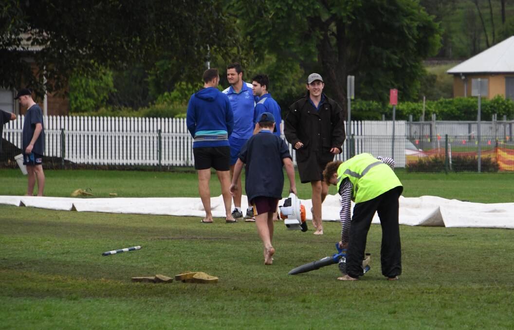 WASH-OUT: Easts players and volunteers try to dry out King Edward Park to allow for play on Saturday. Picture: Michael Hartshorn