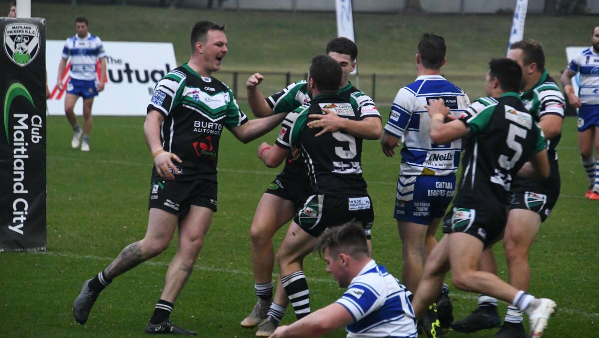 Pickers players race in to congratulate Jarrod Smith after he scores a try.