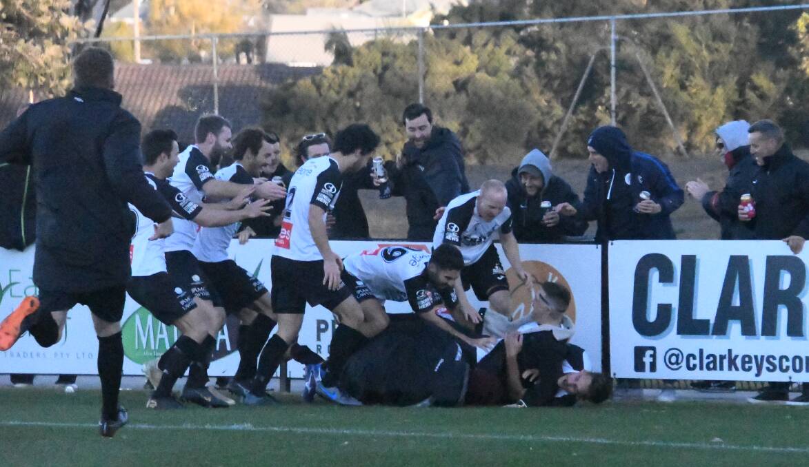 JUBILANT: Maitland players and supporters celebrate Matt Thompson's winning goal which lifted the club two points clear at the top of the NPL ladder. Picture: Michael Hartshorn
