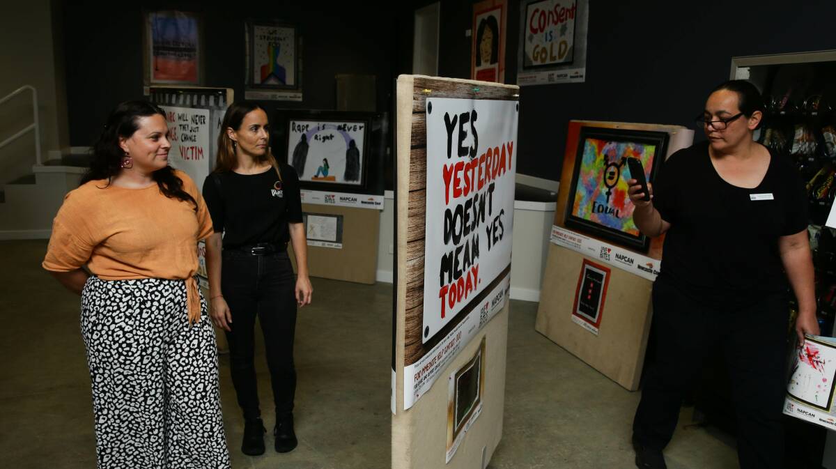 STRONG MESSAGES: Dayle Fogarty, Grace Folkard and Rosa Grine check out the works on display at the Love Bites community poster campaign launch. Picture: Jonathan Carroll