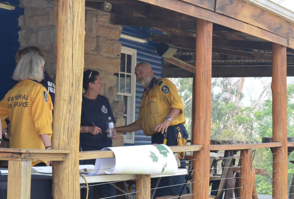 INFORMATION: Rural Fire Service volunteers at the community information post at Wollombi Tavern on Tuesday. Picture: Krystal Sellars
