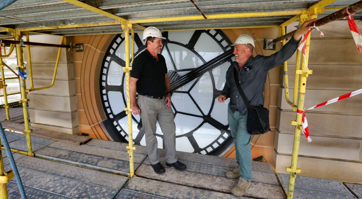 ON TIME: Kevin Moriarty and Rick Timperi at the northern face of the newly-restored Newcastle City Hall clock tower. Picture: Jonathan Carroll.