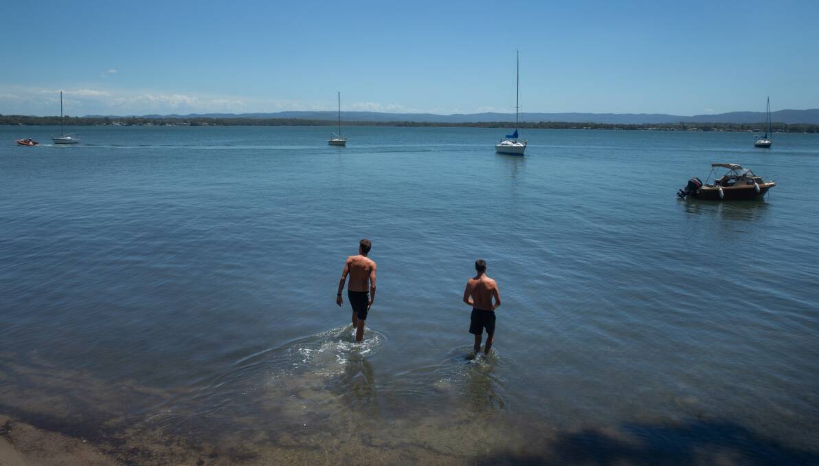 DEFIANCE: Bruce Moir and Jake Newell go for a dip on Sunday afternoon a few houses along from where Saturday's attack took place. Picture: Marina Neil