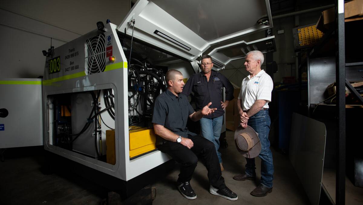  ON THE JOB: Stuart Bond, seated, and Senator Malcolm Roberts, flank Andrew George from ACE Mechanical Solutions at Rutherford. Picture: Marina Neil