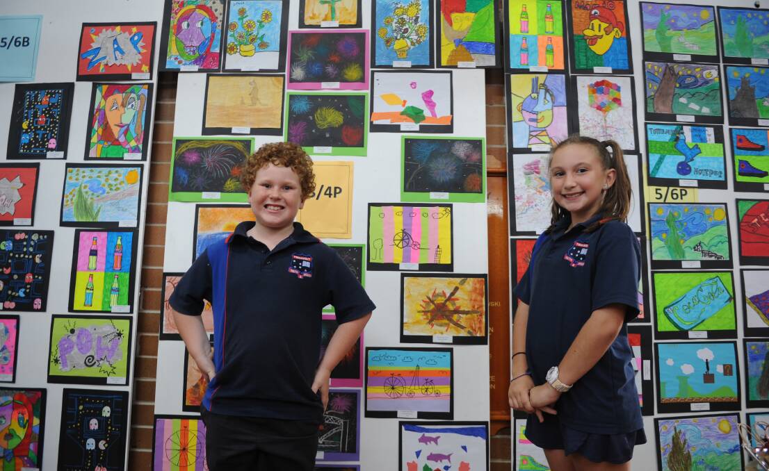 YOUNG ARTISTS: Tenambit Public School students Alex Brown and Eliza Blakemore stand in front of some of the student works that were displayed at the art show.