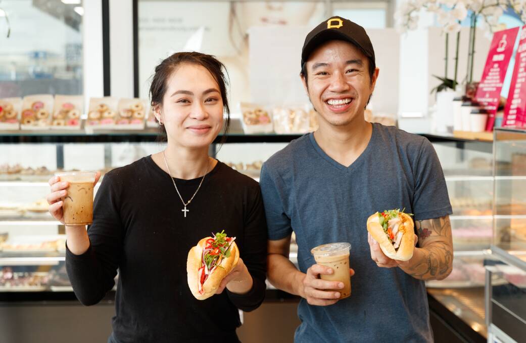 LOVING LIFE: Rutherford's M&M Bakehouse owners Melissa Do and Patrick Vu with a traditional Banh Mi and a crispy Banh Mi, and Vietnamese iced coffees. Picture: Max Mason-Hubers