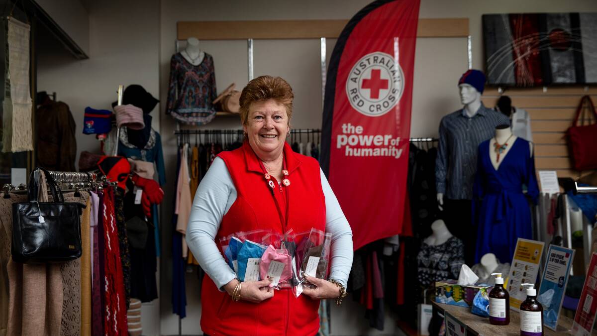 IN DEMAND: Volunteer Trish Miller with some of the handmade masks at the Australian Red Cross store in The Levee. Picture: Marina Neil